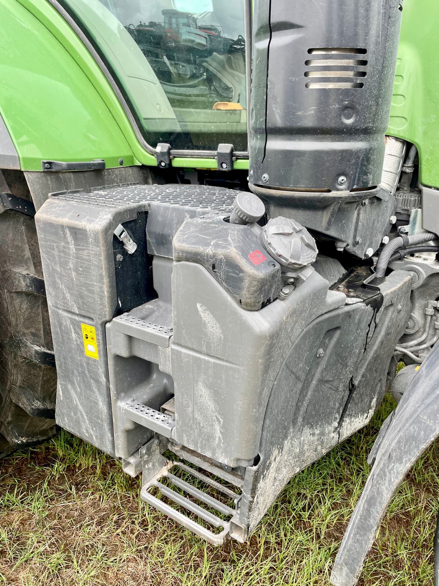 Grimy tractor fuel tank and step area before cleaning